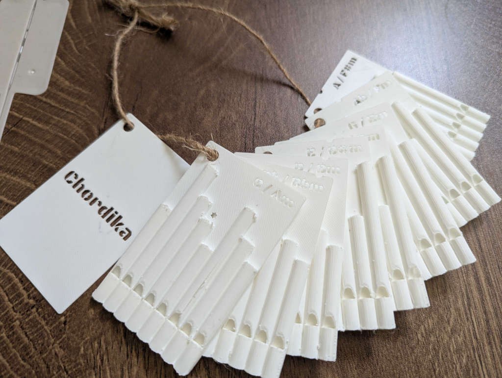 The twelve Chordika cards, printed in white PLA and bound with twine
